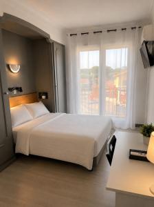 a hotel room with a large bed and a window at Hôtel le Canetois in Canet-en-Roussillon