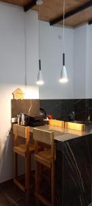 a kitchen with a counter with two chairs and two lights at Quinta Sinaí in Encarnación