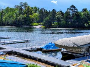 a couple of boats parked at a dock on a lake at 2BR 1BA Cabin #8 at Riverside Point Resort in Park Rapids