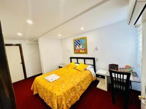 a bedroom with a yellow bed and a desk at Le Prince Arica in Arica +22 photos