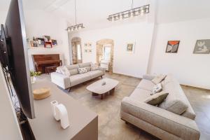 a living room with two couches and a table at Heritage House Strahinja Stone Villa with Private Pool in Popovići