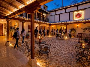 a group of people walking around a courtyard at night at RETIRO DEL TEATRO Hotel Boutique y Apartamentos en Almagro in Almagro +128 photos