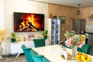 a dining room with a table and a fireplace at Villa Mali Raj in Čapljina
