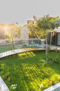 a yard with a fence and a garden with flowers at Villa Mali Raj in Čapljina