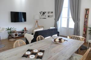 a living room with a wooden table and a living room with a couch at Appartement vue imprenable sur la Loire !!! in Saumur