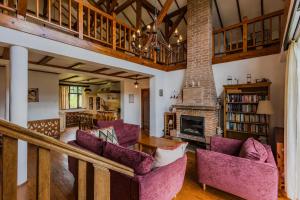 a living room with purple chairs and a fireplace at Casa Koenigstein Private Hilltop Villa in Fundata