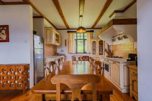 a large kitchen with a wooden table and chairs at Casa Koenigstein Private Hilltop Villa in Fundata