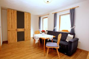 a living room with a table and a couch at Knotzenlehen in Ramsau +16 photos