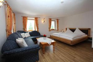 a living room with a couch and a bed at Knotzenlehen in Ramsau