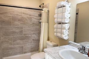 a bathroom with a shower and a toilet and a sink at Old Faithful RV Park LLC in Cody