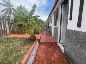 a brick walkway next to a house with palm trees at Ti Francois in Le François