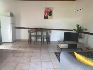 a living room with a table and chairs and a refrigerator at Ti Francois in Le François +10 photos