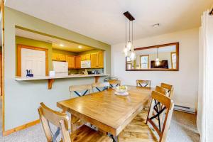 a dining room and kitchen with a wooden table and chairs at Casa Lontano in Tannersville