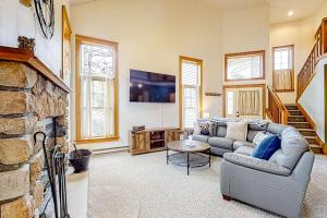 a living room with a couch and a stone fireplace at Casa Lontano in Tannersville