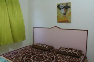 a bed with two pillows on it in a room at kluanghomestayvilla in Kluang