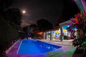 a swimming pool in front of a house at night at Icaraí Bed & Breakfast in Niterói