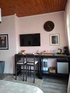 a desk with two chairs and a clock on a wall at Room De LUX SPA " TABARKA " in Spa +17 photos