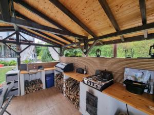 a large outdoor kitchen with a stove and counters at Cozy Lake House in Cinciş