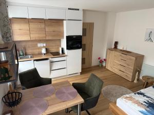a room with a kitchen and a table and a room with a bed at Apartment WOLF in Kořenov
