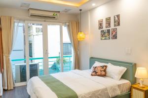 a bedroom with a bed and a balcony at Hanoi Olive Boutique in Hanoi