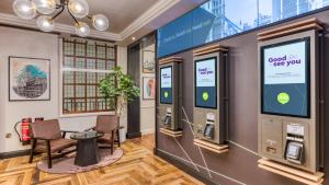 a room with two atm machines on a wall at hub London Farringdon - Old Bailey in London +22 photos