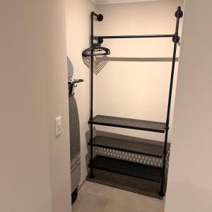 a walk in closet with three black shelves at Apartment MessePark Bad Salzuflen in Bad Salzuflen +2 photos