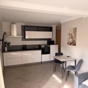 a kitchen with white cabinets and a table with chairs at Apartment MessePark Bad Salzuflen in Bad Salzuflen