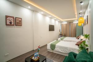 a hotel room with a bed and a couch at Hanoi Olive Boutique in Hanoi