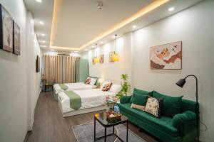 a hotel room with a bed and a green couch at Hanoi Olive Boutique in Hanoi