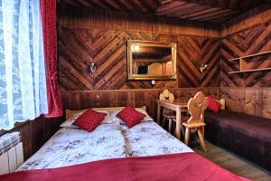 a bedroom with a bed and a table and a mirror at Pokoje Gościnne Za Wnukiem in Zakopane