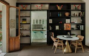 a dining room with a table and a book shelf at Casa Seis Siete in Mexico City