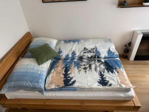 a bed with a blanket with a dog on it at Apartment WOLF in Kořenov