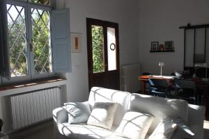 a living room with a white couch and windows at Casa della Consolazione in Todi