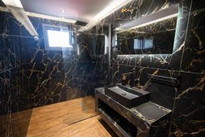 a black marble bathroom with a sink and a mirror at Divodi View in Mytikas +42 photos