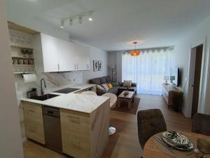 a kitchen and a living room with a couch at Las gaviotas,playa,piscinayparking in Malpica