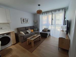 a living room with a couch and a table at Las gaviotas,playa,piscinayparking in Malpica
