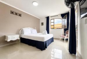 a bedroom with a bed and a window and a chair at Hotel Suite Santa Rosa in Santa Rosa de Cabal +113 photos