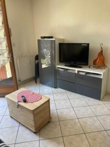 a living room with a flat screen tv and a table at L'Esperluette in Thyez