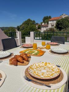 a table with plates of food and bread on it at Port'Espada Countryhouse in Marvão