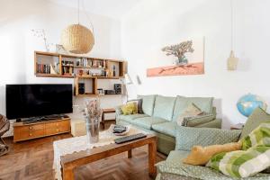 a living room with two couches and a tv at Hospedaje La Casa del Ceibo in Córdoba