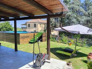 a patio with an umbrella and a pool at Le vigne in Asti