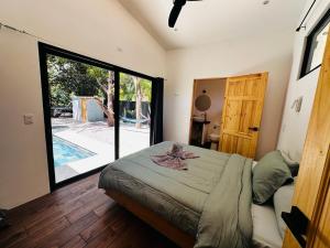 a bedroom with a bed and a large sliding glass door at Between Waves and Woods in Sámara