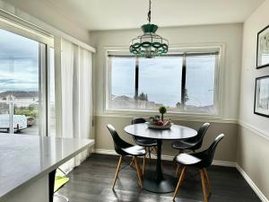 a dining room with a table and chairs and a window at Ocean View Home Nanaimo in Nanaimo