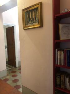 a painting on a wall next to a book shelf at Villa Maddalena - Cerrolungo in Isola