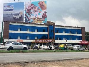 a large building with cars parked in front of it at SLV Royal Residency Hotel in Bidadi