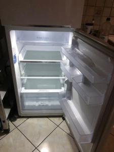 an empty refrigerator with its door open in a kitchen at L'Esperluette in Thyez
