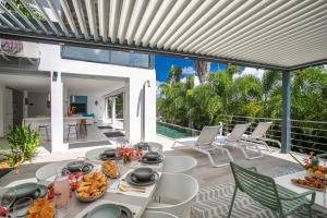 an outdoor dining area with a table with food on it at Karibu House in Les Trois-Îlets