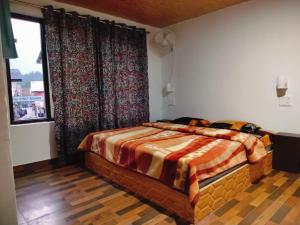 a bedroom with a bed and a window at New Heaven Rose in Pahalgām