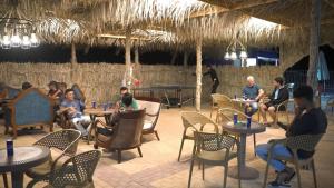 a group of people sitting at tables in a restaurant at Ghazala resort in Marsa Matruh