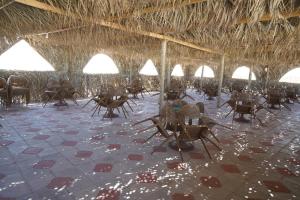 a room with chairs and tables and a straw roof at Ghazala resort in Marsa Matruh +19 photos